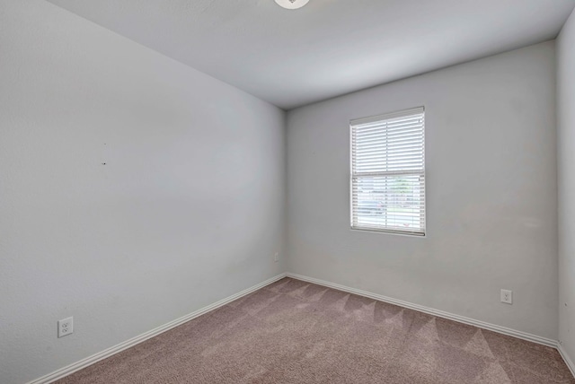 unfurnished room featuring carpet and baseboards