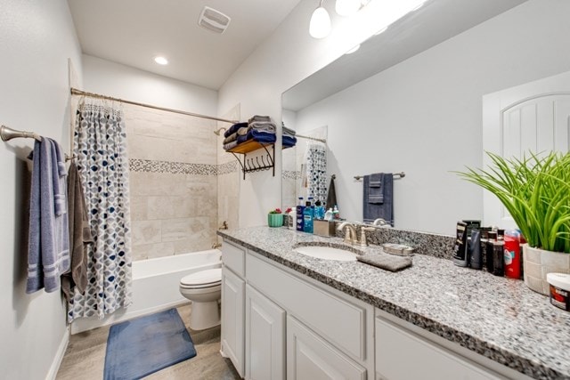 full bathroom featuring visible vents, baseboards, toilet, shower / bath combination with curtain, and vanity