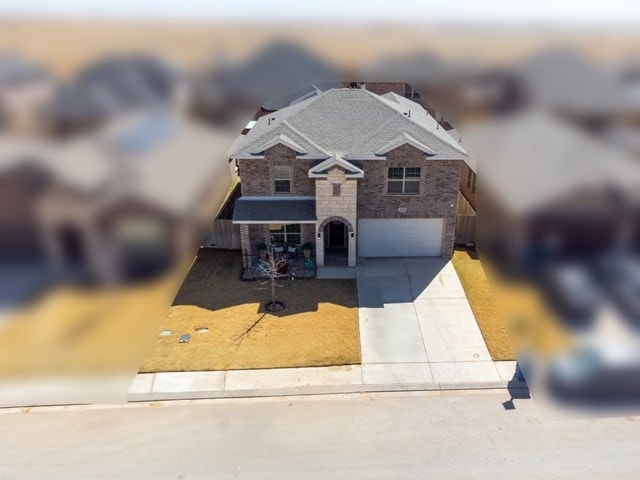 view of front facade featuring concrete driveway, a garage, and stone siding