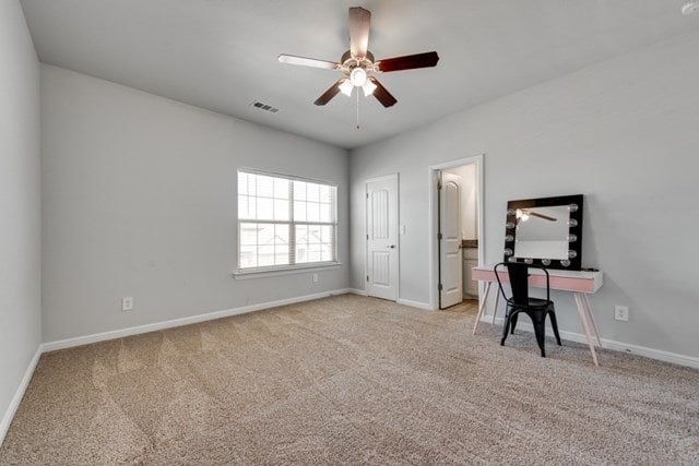 interior space with visible vents, baseboards, light colored carpet, and ceiling fan