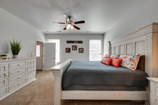 bedroom with light carpet, visible vents, and a ceiling fan