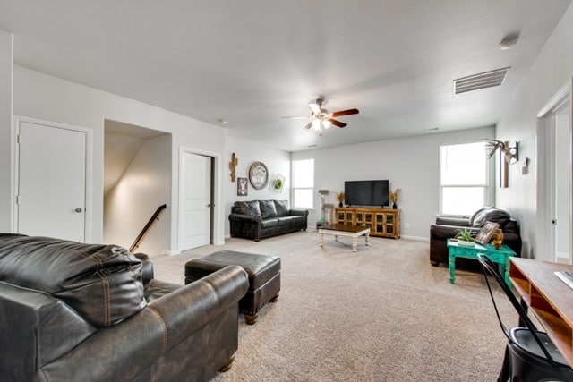 living area featuring carpet flooring, ceiling fan, and visible vents