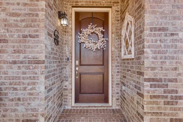 doorway to property featuring brick siding