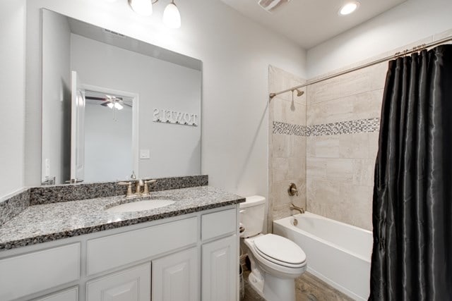 bathroom with vanity, visible vents, ceiling fan, shower / tub combo, and toilet