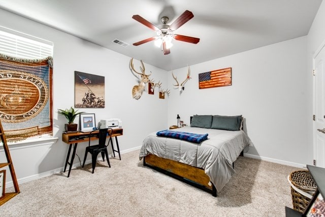 carpeted bedroom featuring a ceiling fan, baseboards, and visible vents