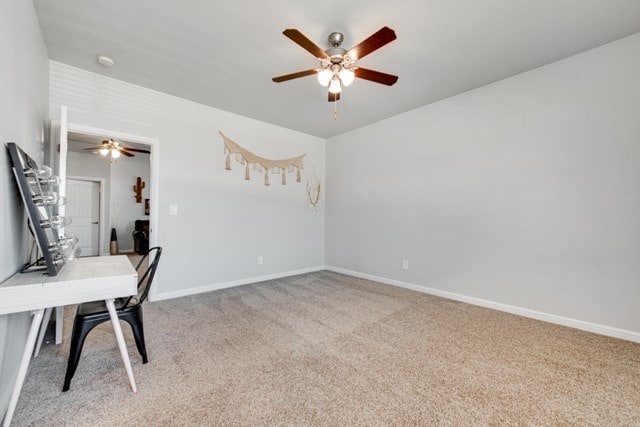 unfurnished office with light colored carpet, baseboards, and ceiling fan