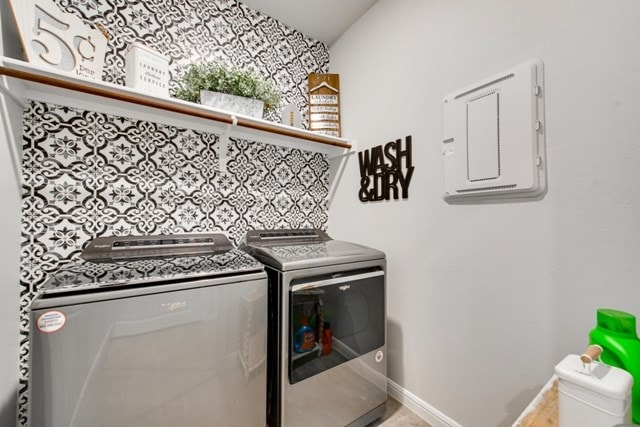 washroom with electric panel, baseboards, washing machine and dryer, and laundry area