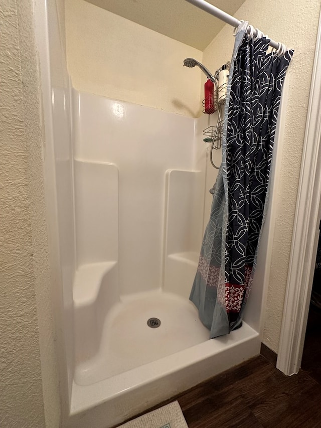 bathroom featuring hardwood / wood-style floors and walk in shower