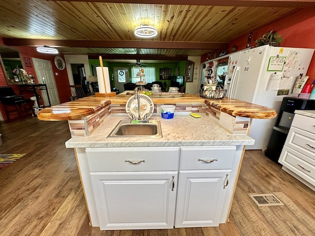 kitchen featuring light hardwood / wood-style floors, sink, white cabinetry, and an island with sink