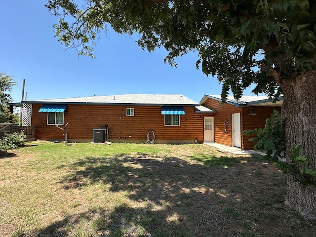 rear view of property with a yard and cooling unit