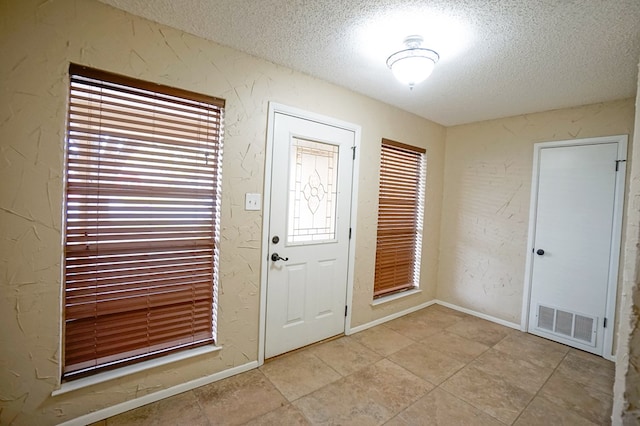 foyer entrance with a textured ceiling