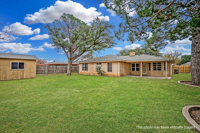 rear view of property featuring a yard and a patio area