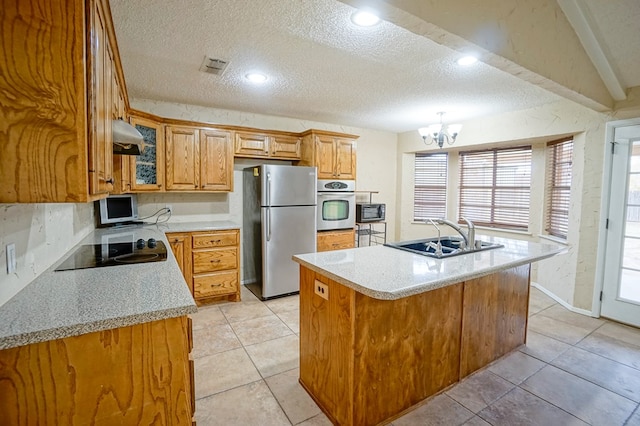 kitchen with an inviting chandelier, sink, a textured ceiling, an island with sink, and appliances with stainless steel finishes