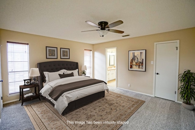 carpeted bedroom featuring ceiling fan, a textured ceiling, connected bathroom, and multiple windows