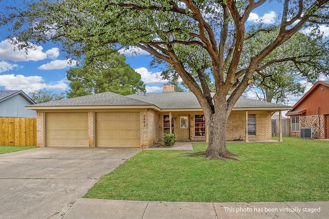 ranch-style house with a front yard, a garage, and central air condition unit