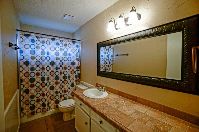 bathroom with vanity, a textured ceiling, toilet, and curtained shower