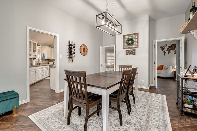 dining room featuring baseboards, dark wood finished floors, and a chandelier