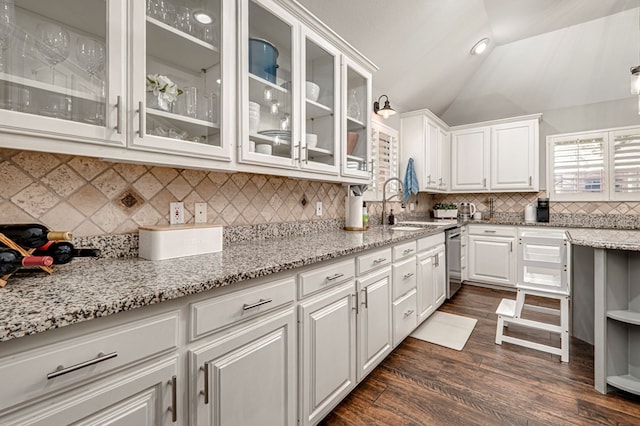 kitchen featuring white cabinets, light stone countertops, dark wood finished floors, and stainless steel dishwasher