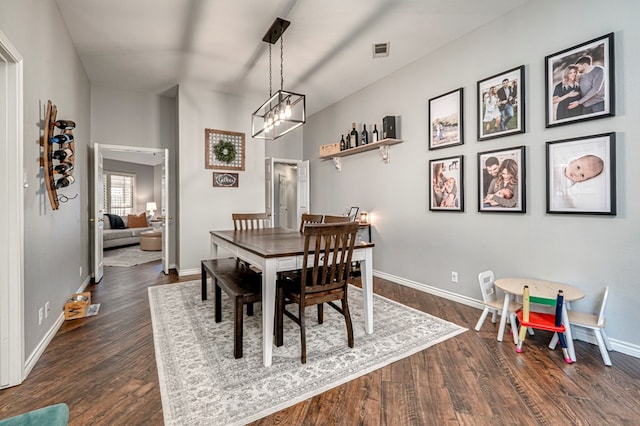 dining area with visible vents, dark wood finished floors, baseboards, and a chandelier