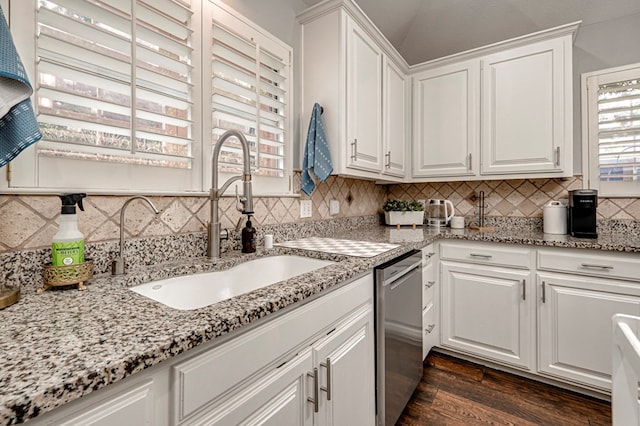 kitchen featuring backsplash, stainless steel dishwasher, a sink, dark wood-style floors, and white cabinetry