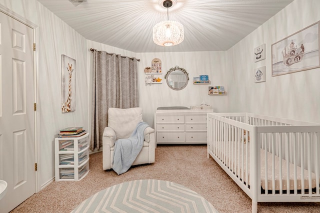 carpeted bedroom with a nursery area