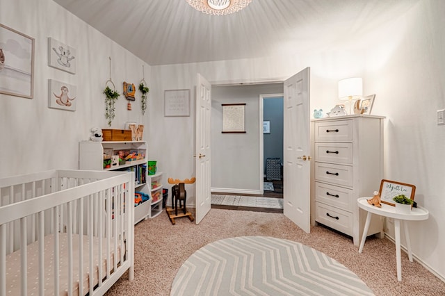 bedroom with baseboards, light colored carpet, and a crib