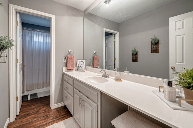 full bath featuring vanity, baseboards, and wood finished floors