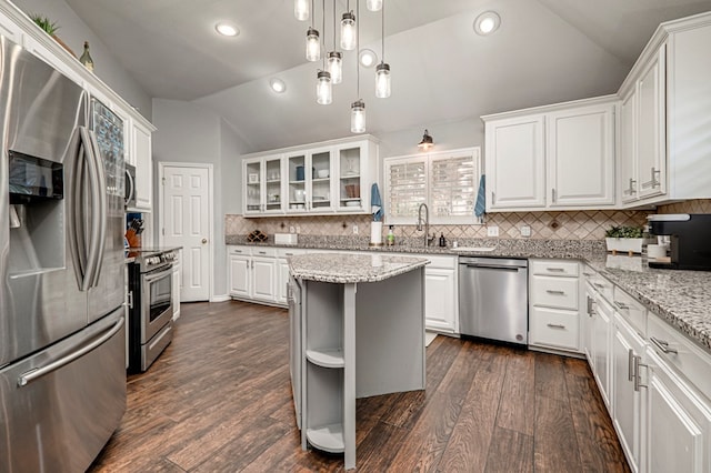 kitchen with dark wood-style flooring, white cabinets, vaulted ceiling, and stainless steel appliances
