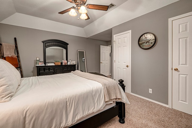 carpeted bedroom with baseboards, ceiling fan, a tray ceiling, and visible vents