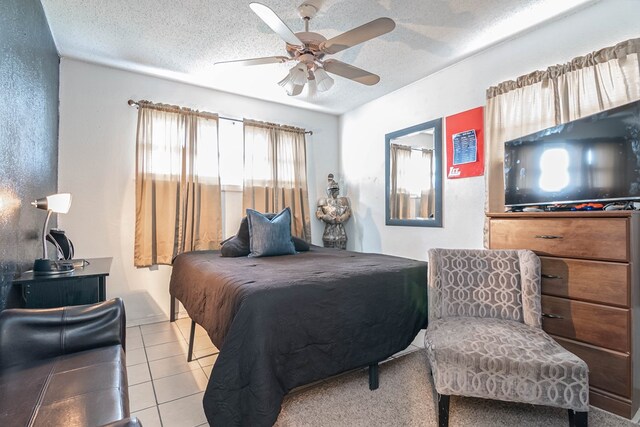 bedroom featuring light tile patterned floors, a textured ceiling, and ceiling fan