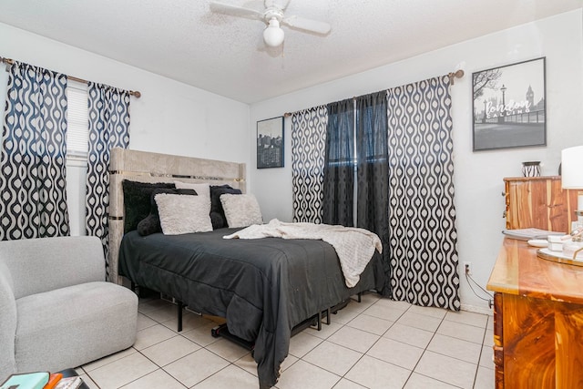 bedroom with light tile patterned flooring, ceiling fan, and a textured ceiling