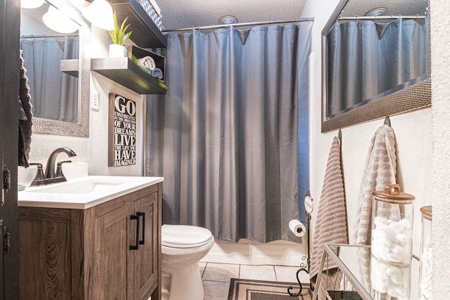 bathroom featuring shower / bath combo, vanity, toilet, a textured wall, and tile patterned flooring