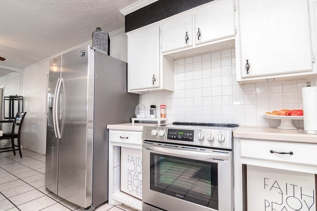 kitchen with stainless steel appliances, light tile patterned floors, backsplash, light countertops, and a textured ceiling