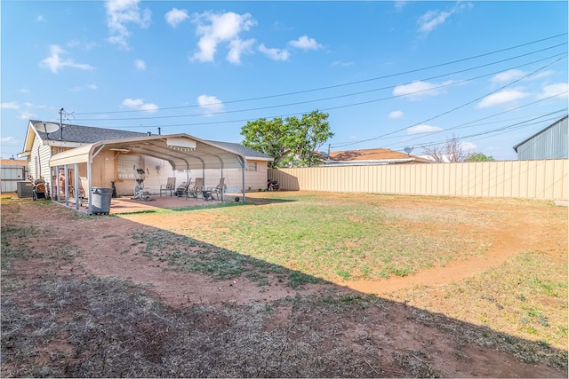 view of yard featuring fence and a carport