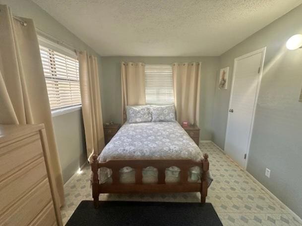 bedroom featuring a textured ceiling and vaulted ceiling