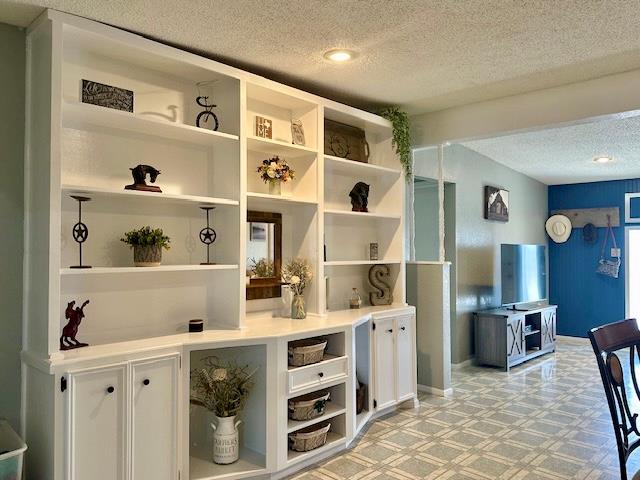 bar featuring white cabinetry and a textured ceiling