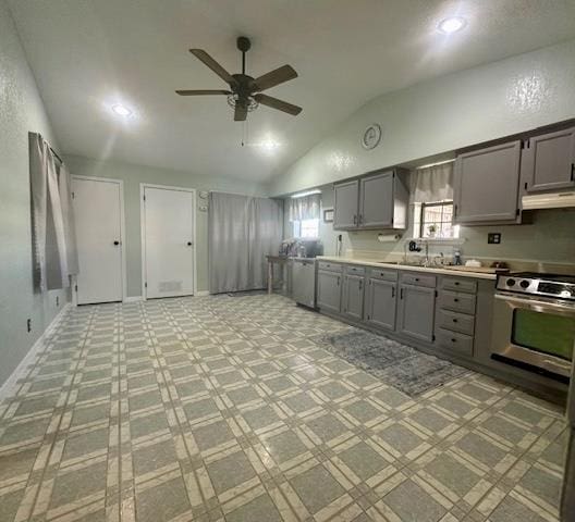 kitchen featuring sink, vaulted ceiling, gray cabinetry, and stainless steel stove