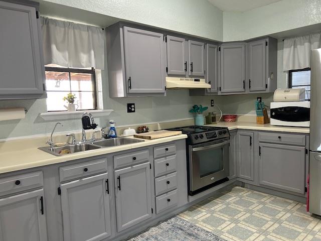 kitchen with sink, stainless steel range, and gray cabinetry