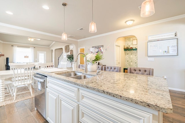 kitchen featuring dishwasher, sink, dark wood-type flooring, crown molding, and a kitchen island with sink