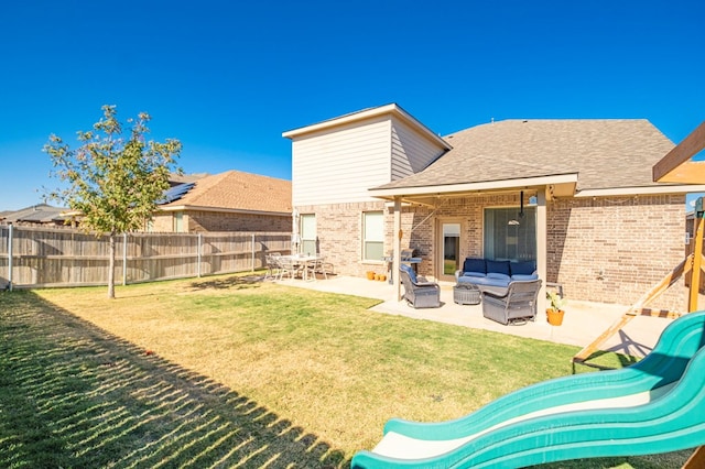 rear view of property featuring a lawn, outdoor lounge area, and a patio