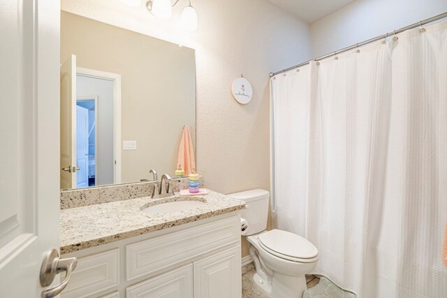 bathroom with tile patterned floors, vanity, and toilet