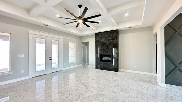 unfurnished living room with french doors, ceiling fan, a high end fireplace, and coffered ceiling