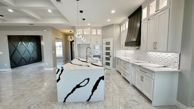 kitchen featuring white cabinetry, white appliances, a kitchen island with sink, and pendant lighting