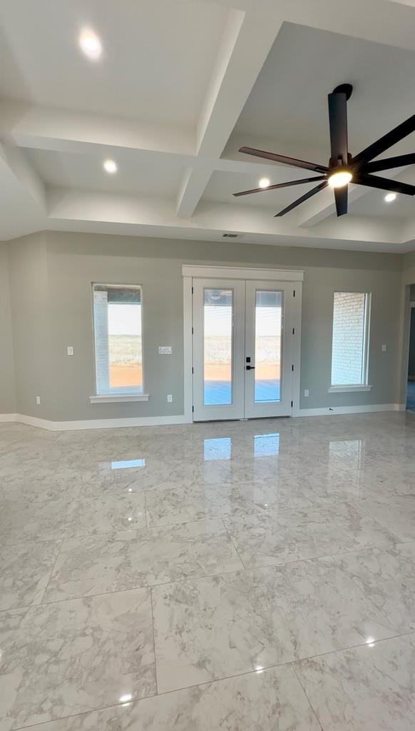 spare room with french doors, ceiling fan, coffered ceiling, and a wealth of natural light