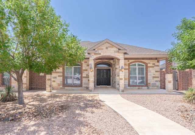 7604 Keyhaven, Odessa, TX 79765 - french country inspired facade featuring stone siding, roof with shingles, and brick siding