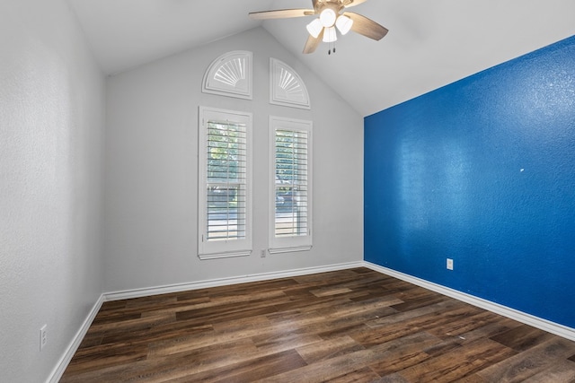 empty room with dark hardwood / wood-style flooring, lofted ceiling, and ceiling fan