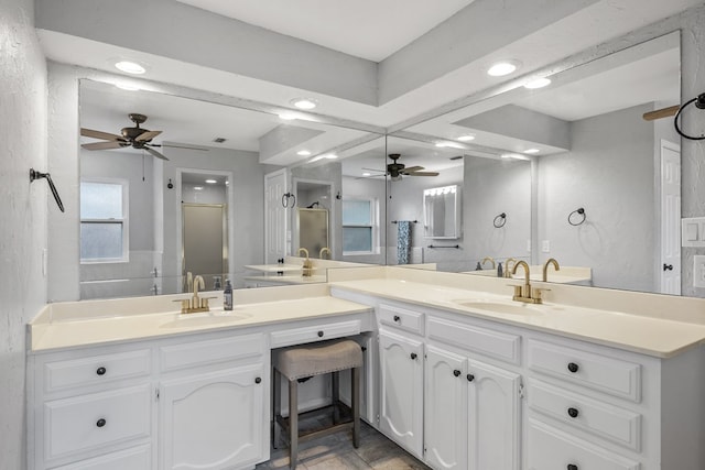 bathroom with ceiling fan, vanity, and a shower with door