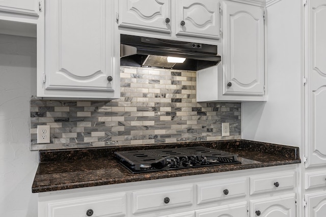 kitchen featuring white cabinetry, dark stone counters, decorative backsplash, exhaust hood, and black gas stovetop