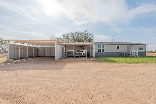 50031 E County Rd 71, Midland, TX 79705 - back of house with dirt driveway, a carport, and central air condition unit