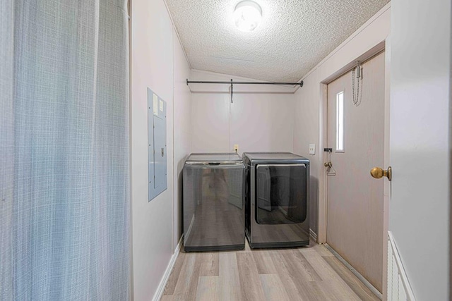 50031 E County Rd 71, Midland, TX 79705 - laundry room with washer and clothes dryer, a textured ceiling, light wood finished floors, electric panel, and baseboards